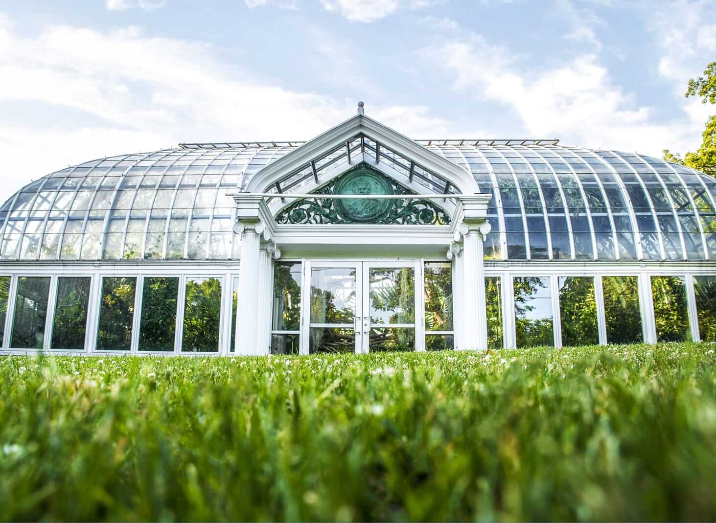 The Highland Park Conservancy boasts a stunning glass conservatory with clear domed windows, set against a vibrant blue sky. Its front showcases an elegant decorative triangular pediment, while lush green grass fills the foreground, enhancing its natural beauty. The Highland Park Conservancy boasts a stunning glass conservatory with clear domed windows, set against a vibrant blue sky. Its front showcases an elegant decorative triangular pediment, while lush green grass fills the foreground, enhancing its natural beauty.