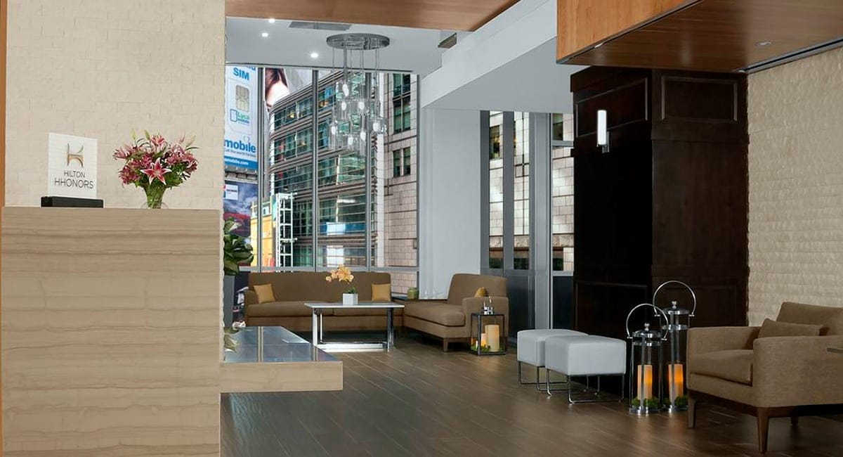 The hotel's lobby with an view of the New York City skyline and Times Square below. | Photo from Hilton Garden Inn Times Square Central
