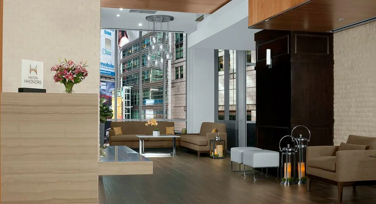 The hotel's lobby with an view of the New York City skyline and Times Square below. | Photo from Hilton Garden Inn Times Square Central