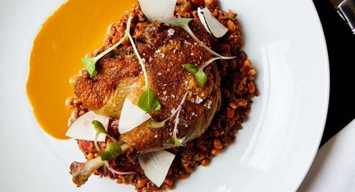 The duck confit from Fazio Farms. Plated over Jefferson red rice perloo with radish and an oyster dressing. | Photo from Wm Farmer and Sons