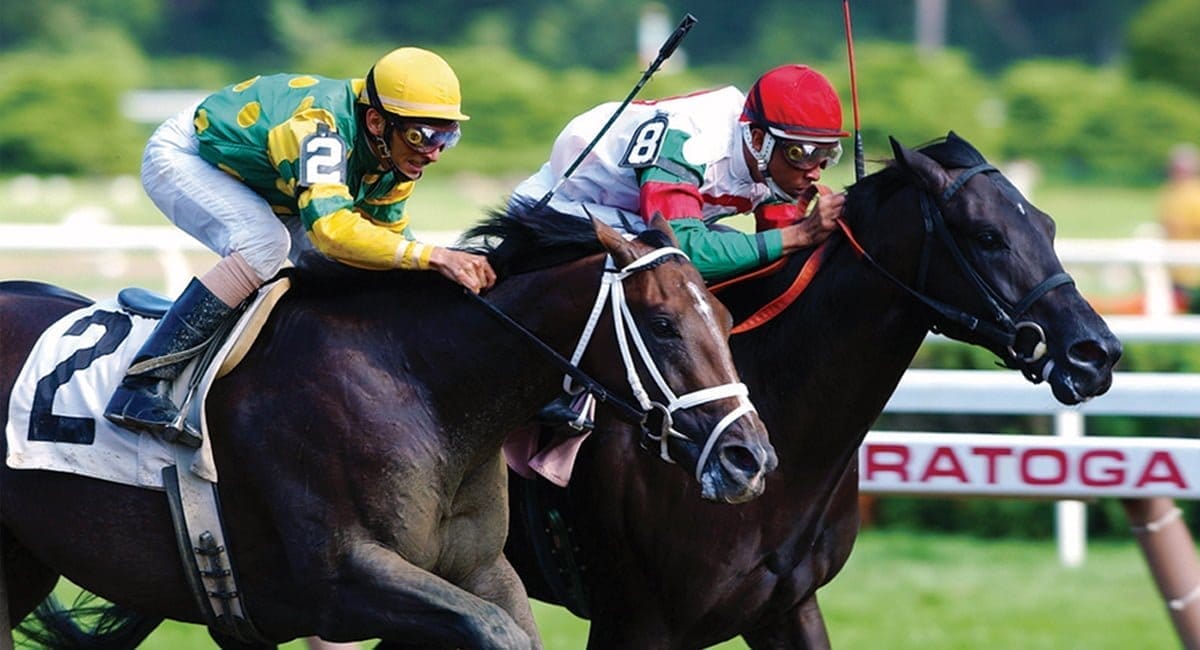 Two jockeys compete fiercely in a horse race, embodying the rich history of horsemanship. One wears green and yellow, the other red and green, as they ride side by side on dark-colored horses, with a sign reading Saratoga in the background. Two jockeys compete fiercely in a horse race, embodying the rich history of horsemanship. One wears green and yellow, the other red and green, as they ride side by side on dark-colored horses, with a sign reading Saratoga in the background.
