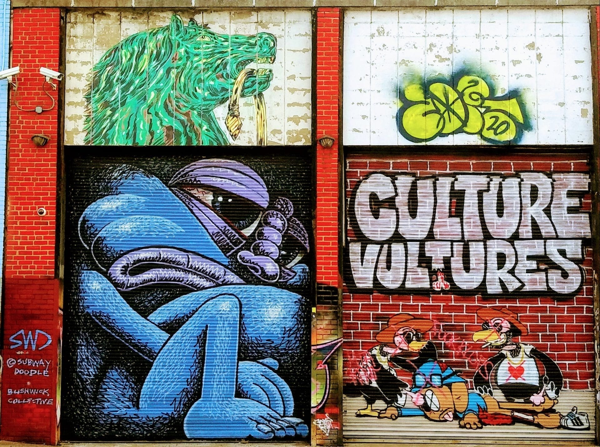 A large mural on a brick wall captures the essence of off-beat experiences to enjoy in New York City. It features three sections: a green lion with a pipe, an abstract purple figure, and two vultures in suits with CULTURE VULTURES above them. Graffiti art and tags add to its eclectic charm. A large mural on a brick wall captures the essence of off-beat experiences to enjoy in New York City. It features three sections: a green lion with a pipe, an abstract purple figure, and two vultures in suits with CULTURE VULTURES above them. Graffiti art and tags add to its eclectic charm.