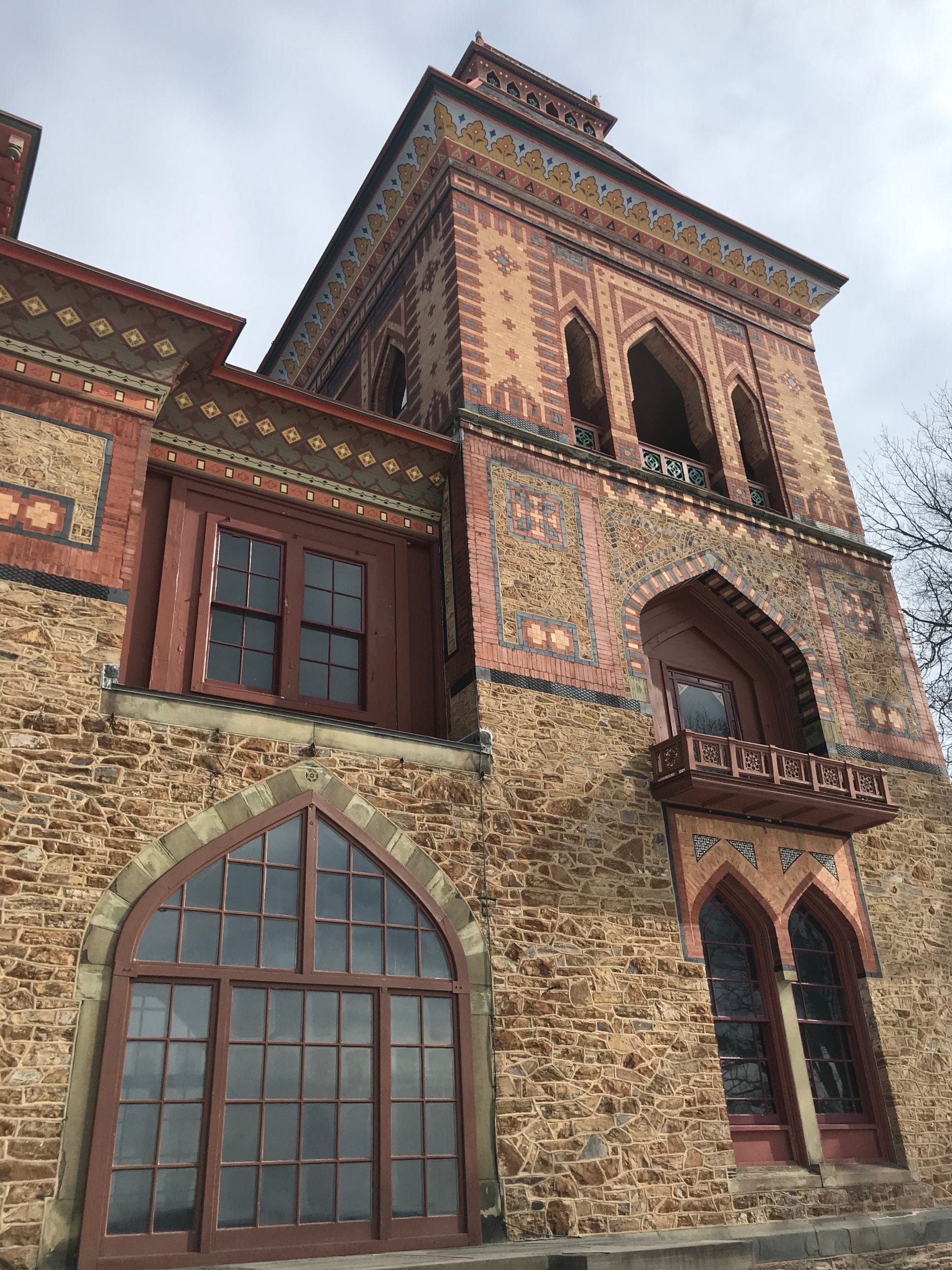 Visiting Hudsons Olana State Historic Site reveals a historic building with ornate brick and stone architecture, arched windows, and colorful patterns. The structure boasts a tall tower and intricate facade details, all set against a moody, cloudy sky. Visiting Hudsons Olana State Historic Site reveals a historic building with ornate brick and stone architecture, arched windows, and colorful patterns. The structure boasts a tall tower and intricate facade details, all set against a moody, cloudy sky.