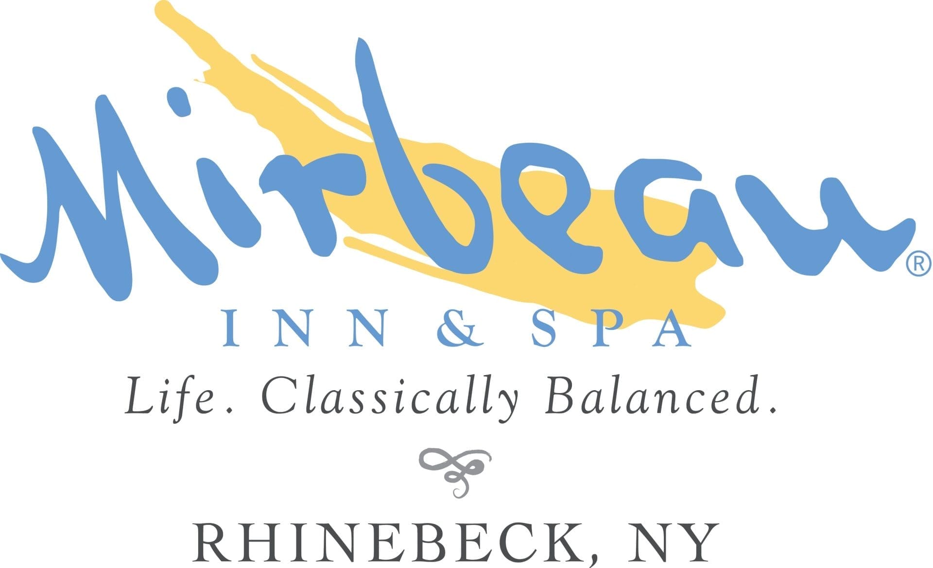 Logo for Mirbeau Inn & Spa. The text reads: Mirbeau Inn & Spa. Life. Classically Balanced. Rhinebeck, NY. Featured in a directory of exclusive retreats, the design includes a splash of yellow behind Mirbeau, reminiscent of elegance found at the Manhattan Club.