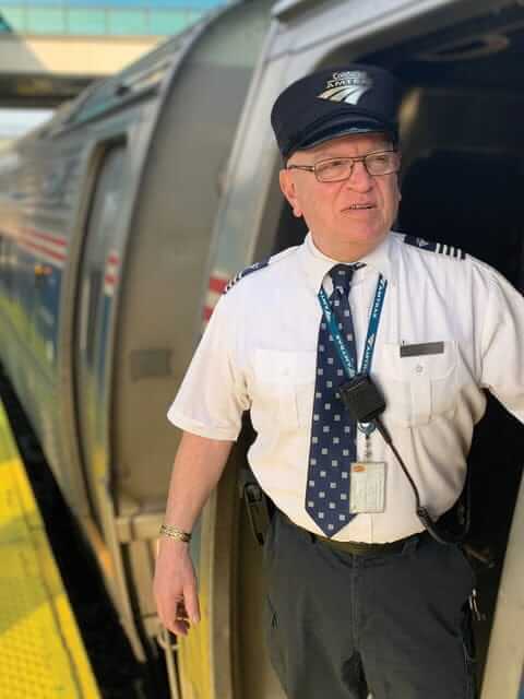Amtrak conductor Marty Quinn in train entryway