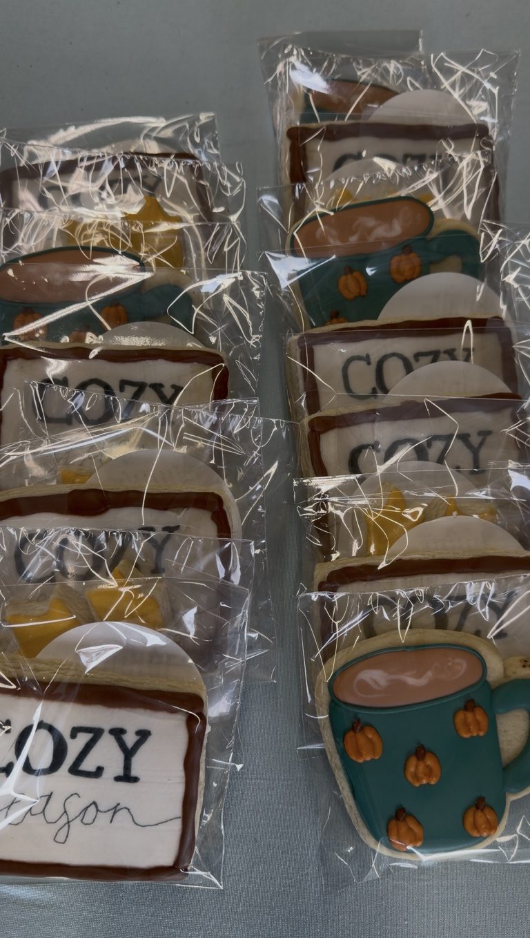 Individually wrapped decorated cookies, some shaped like coffee mugs with pumpkins, and others reading COZY season, arranged in rows—a perfect treat for a journey like Miss New York Explores Albany NY by Amtrak.